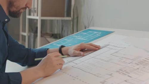 Male Architect Drawing House Plan in Office