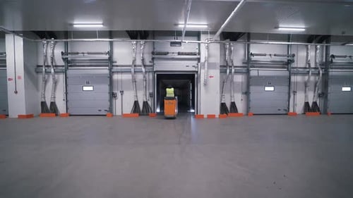 Worker Moves Pallet Load in Warehouse on Jack