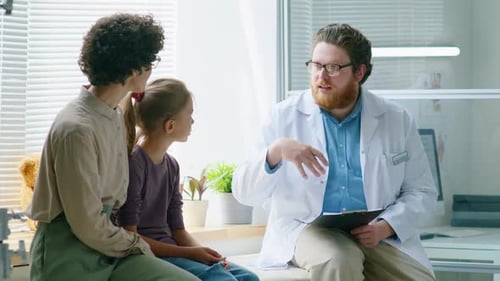 Doctor Talking With Woman and Child in Clinic