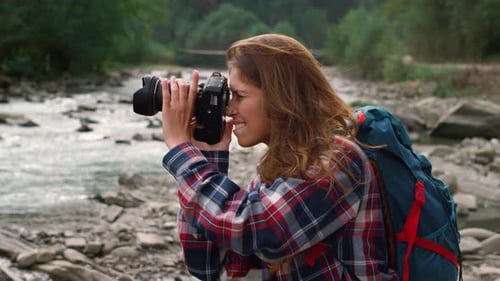 Young Woman Taking Photographs by River