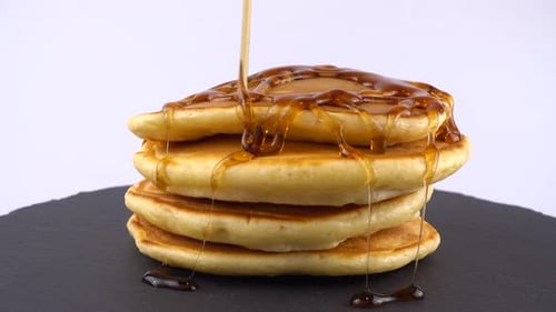 Syrup Poured onto Stack of Pancakes Close Up