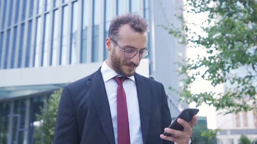 Happy businessman using phone.