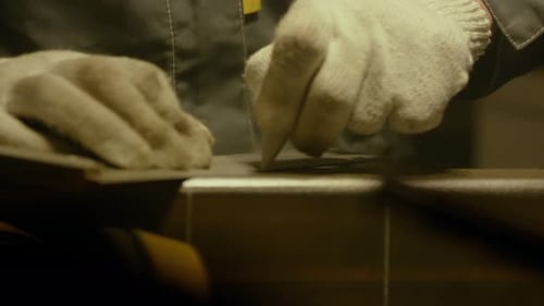 Metalworker in the workshop makes measurements with ruler