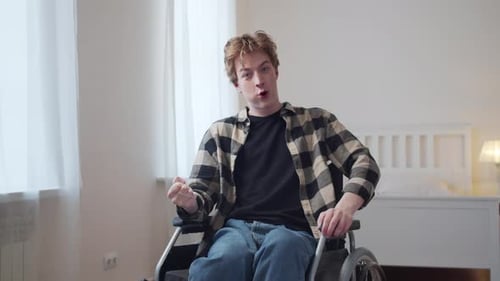 Young Man in Wheelchair Removes Mask and Gestures