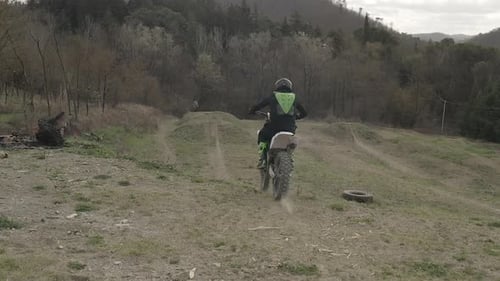Motocross Rider Jumps Motorcycle on Rural Dirt Track