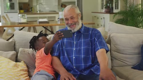 Grandfather and Grandson Take Selfie on Couch