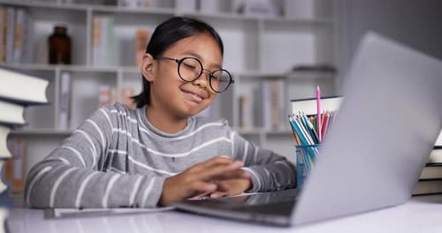 Girl Uses Laptop for Remote Learning at Home