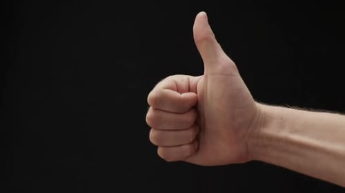 Hand Giving Thumbs Up Gesture on Black