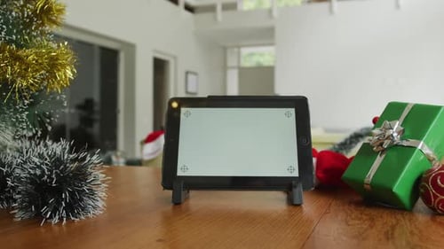 Close up of tablet with copy space on screen, sitting on table in living room at christmas