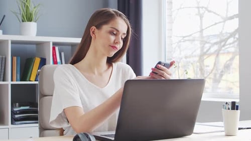 Young Woman Works at Home Office Using Computer.