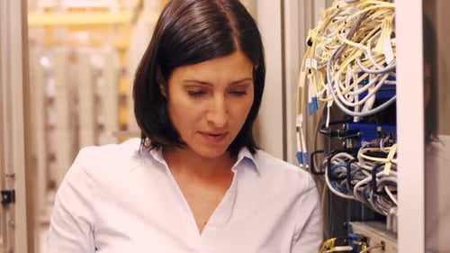 Technician checking cables in a rack mounted server