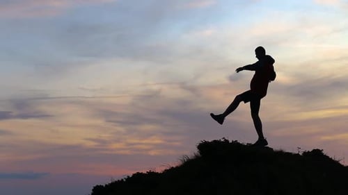 Silhouette Balancing on Hill at Sunset