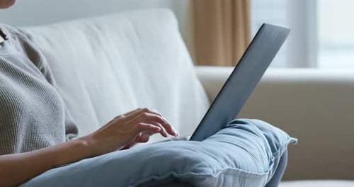 Woman Using Laptop on Light Colored Couch