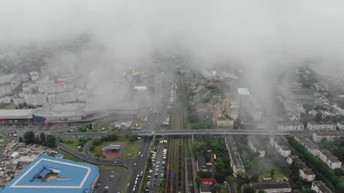 Aerial View of City infrastructure With Roads, Railroad Tracks, and Buildings on a Foggy Day