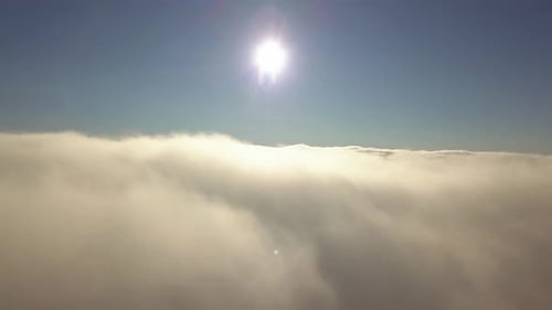 Aerial view from above of white puffy clouds.