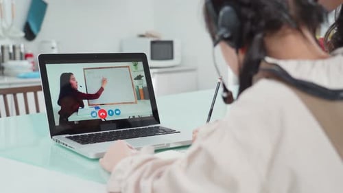 Homeschool Asian little young girl learn online class from school teacher by digital remote at home.