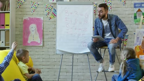 Young Man Teaching Kids in Comfortable Classroom