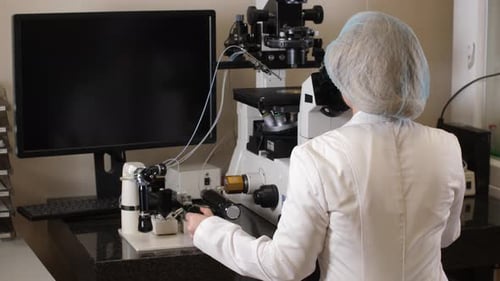 Female Scientist Working with Microscope in Laboratory
