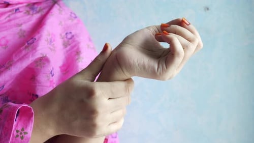 Woman Holding Sore Wrist in Indoor Setting