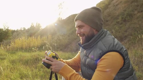 Man Taking Pictures Outdoors in a Sunny Field