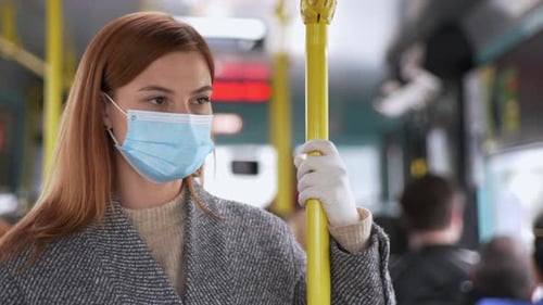 Woman Riding Public Transportation Wearing Mask and Gloves