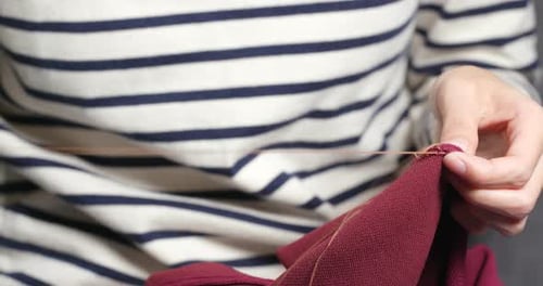 Hand Sews with A Needle and Thread at Home