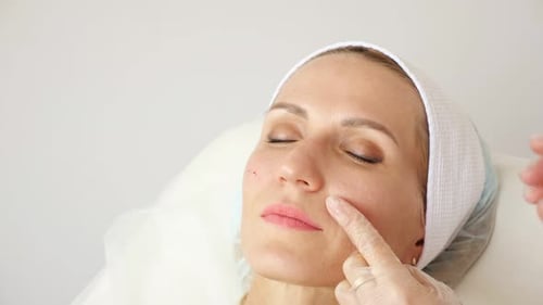 Woman Receiving Facial Injection in Clinical Environment