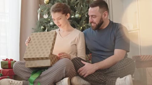 Couple Opening Christmas Gift Together at Home