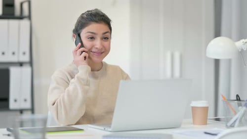 Smiling Woman Talking on Phone While Working