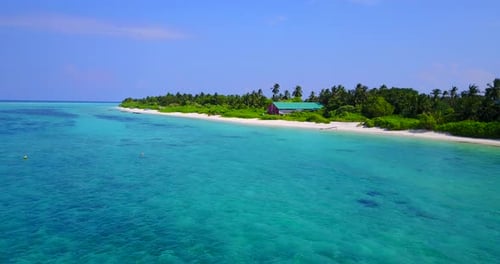Clear calm azure sea water washing white sand of tropical island with palm trees at sunset with purp