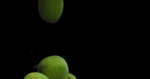 Fresh Green Limes Falling into Water