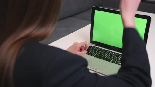 Caucasian businesswoman has video call chatting on laptop with green screen chromakey in office