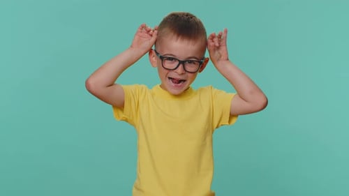 Lustiges Kleinkind Kinder Junge, der verspielte dumme Gesichtsausdrücke macht und Grimassen herumalbern
