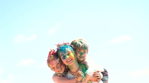 Woman and Children Covered in Holi Powder Embrace