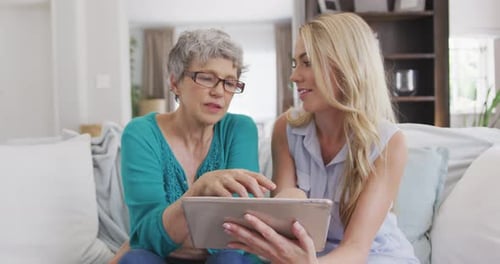 Senior and Adult Woman Using Tablet Together