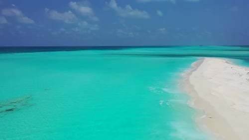 Wide angle fly over island view of a sandy white paradise beach and blue water background in vibrant