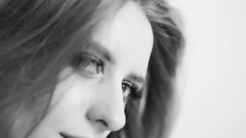 Close-up Portrait of a Beautiful Young Model in the Studio with a White Background. Slow Motion