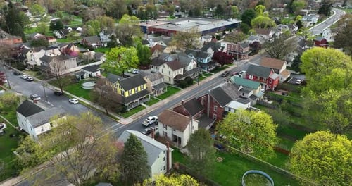 Homes along quiet street in USA. Old fashioned vintage small town America aerial in spring season. C