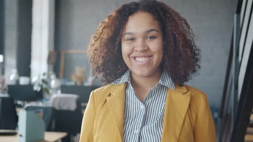 Portrait of Joyful Mixed Race Woman Standing in Office Smiling Looking at Camera