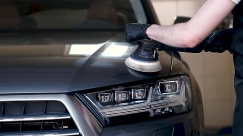 Man Polish a Car in a Garage