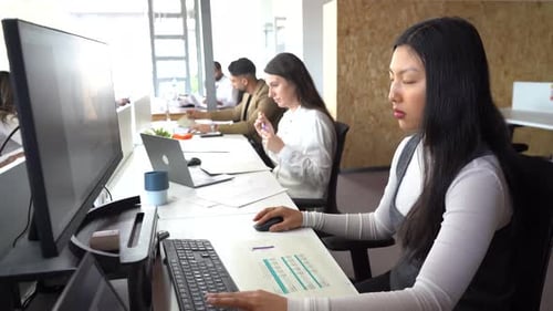 Diverse colleagues working at table in office