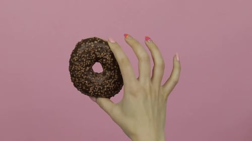 Hand Holding Chocolate Donut with Sprinkles