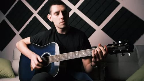 Young Adult Man Playing Acoustic Guitar Sings Home Recording Studio