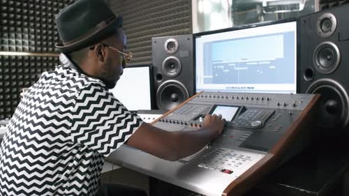 Sound Engineer Using Mixing Desk at Recording Studio