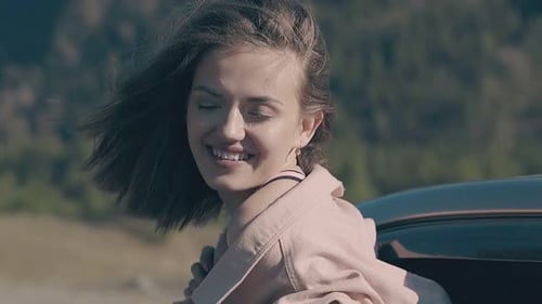 Woman Smiling in Car with Wind Blowing Hair