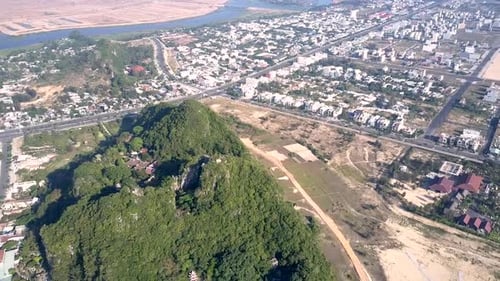 Bird Eye View Green Hill with Temple Roofs Among Modern City