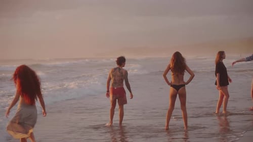 Group of Happy Friends on Beach at Sunset