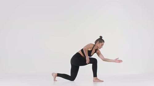 Young Woman Does Yoga Flow Sequence in Studio