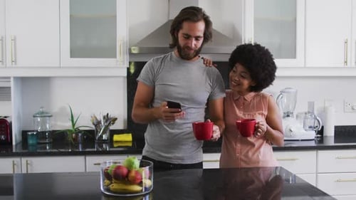 Loving Couple Relaxing in Kitchen with Technology