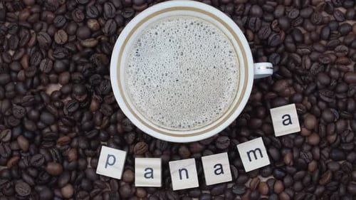 Top View of a Cup of Coffee on a Background Coffee Beans with the Inscription Panama